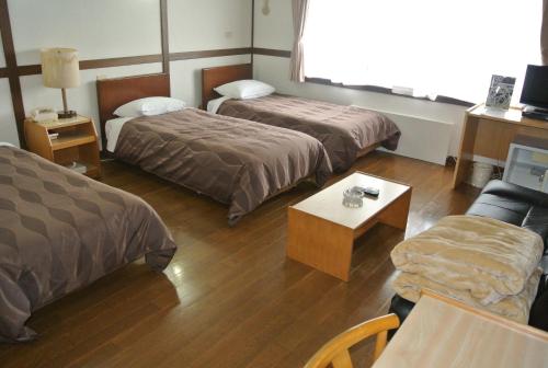 a hotel room with two beds and a couch at Hotel Biwako Plaza in Moriyama