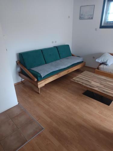 a green couch in a room with a wooden floor at Apartman MWA in Slavonski Brod