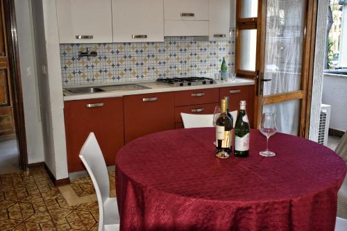 a table with two bottles and two glasses of wine at Hotel Soraya & Apartments in Lignano Sabbiadoro