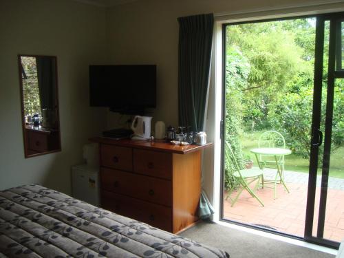 a bedroom with a bed and a sliding glass door at Warkworth Country House in Warkworth