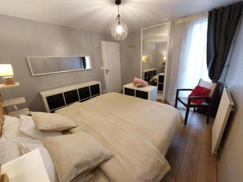 a bedroom with a large bed and a chair at Chambre privée avec Jardin in Les Ulis