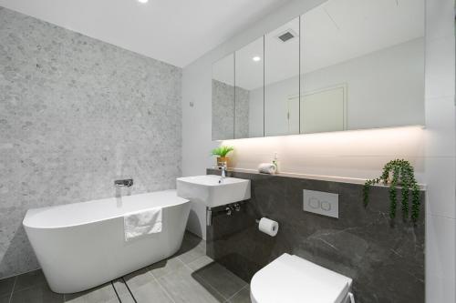 a bathroom with a sink and a toilet and a mirror at 4BR Spacious Townhouse in Box Hill in Annangrove