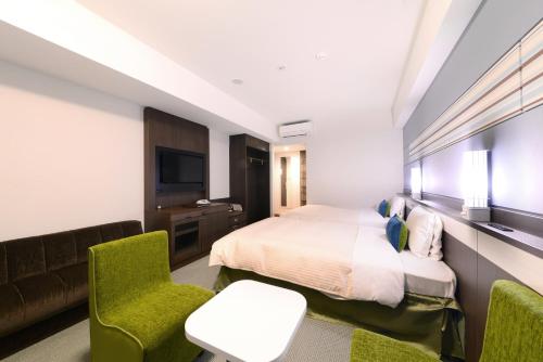 a hotel room with a bed and a couch at Vessel Hotel Campana Okinawa in Chatan