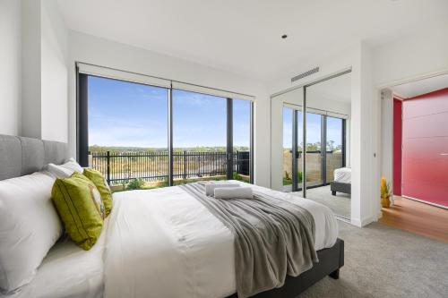 a bedroom with a large bed and large windows at 4BR Spacious Townhouse in Box Hill in Annangrove