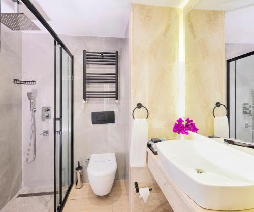 a bathroom with a sink and a toilet and a shower at Elite Hotel Yalıkavak, Bodrum in Yalıkavak