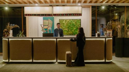 a man and a woman standing at a bar at Ambiance Resort Hunza in Hunza Valley
