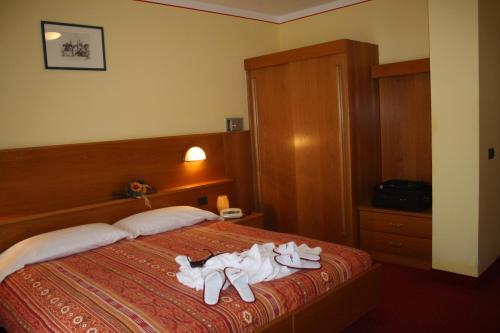 a hotel room with a bed with towels on it at Hotel Michela in Malè