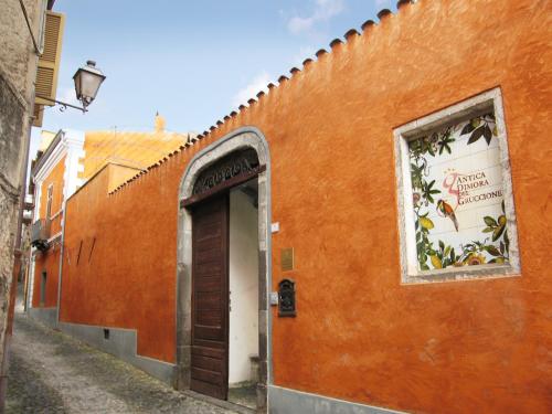 an orange building with a door in a alley at Antica Dimora Del Gruccione, Albergo diffuso in Santu Lussurgiu