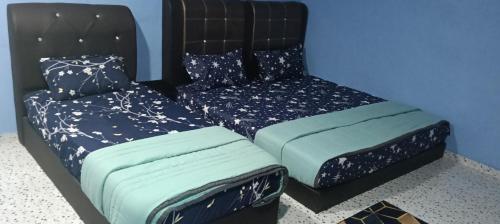 a bed and a chair in a room at Faridd homestay in Kampung Titi Tampang