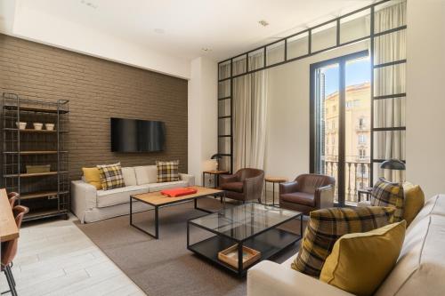 a living room with a couch and a table at Midtown Apartments in Barcelona