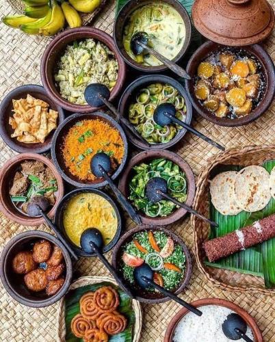 a table topped with bowls of different types of food at Calmira Boutique Stay in Kegalle