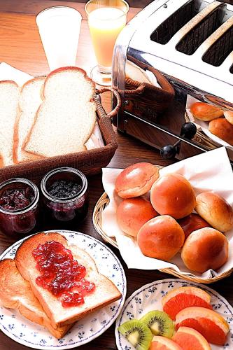 een tafel vol met schalen brood, broodjes en fruit bij Tsuruya Ryokan in Karuizawa