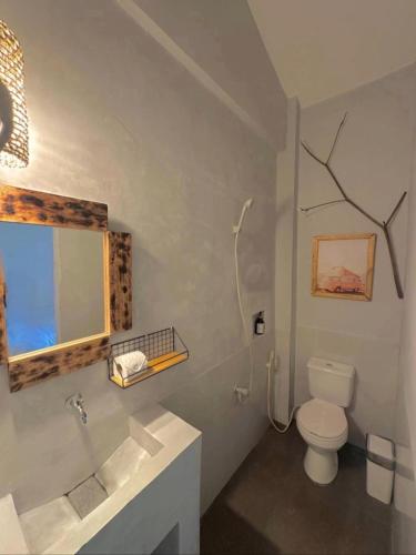 un bagno con un water, un lavandino e uno specchio di Akap Guyam a General Luna