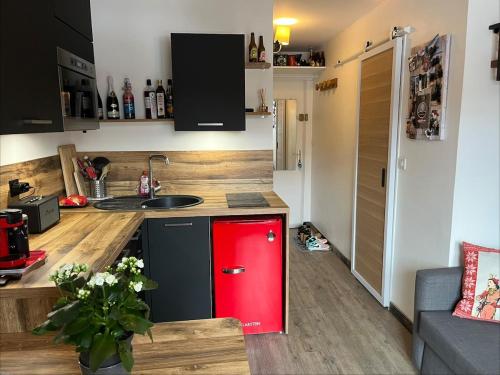 a small kitchen with a red refrigerator and a sink at Ada & Cimes in Bourg-Saint-Maurice