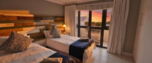 a hotel room with two beds and a large window at 19 Lagoon Terrace in Knysna