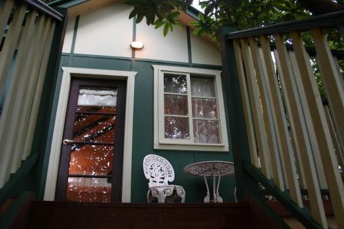 a table and chair on the porch of a house at Lotus Lodges in Sassafras