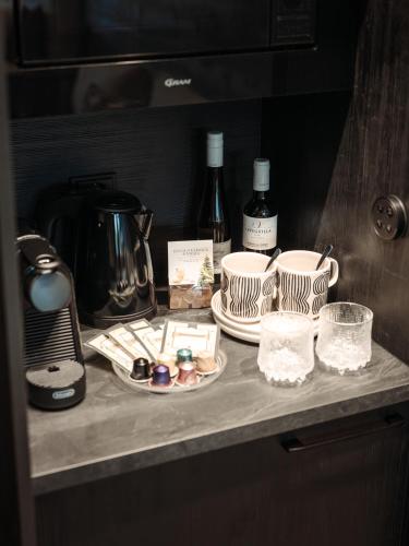 a counter with cups and plates and bottles of wine at Arctic Panorama Resort in Rovaniemi