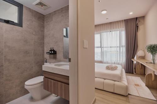 a bathroom with a white toilet and a sink at HongHome Compass One in Ga Phú Văn