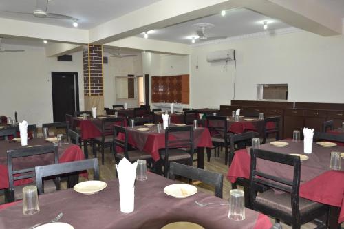 Hotel Joshi في بهيراهاوا: غرفة طعام مع طاولات وكراسي مع قماش الطاولة الحمراء
