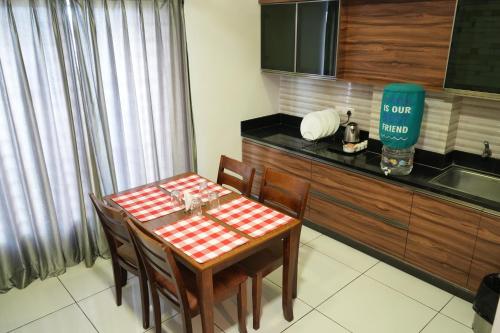 a kitchen with a table and a counter with a sink at Royal Homes in Tallākulam