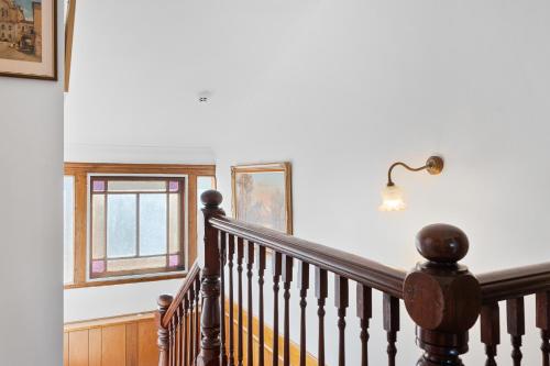 a staircase with a lamp and a window at Magnolia Room, Franklin Lodge Huon Valley in Franklin