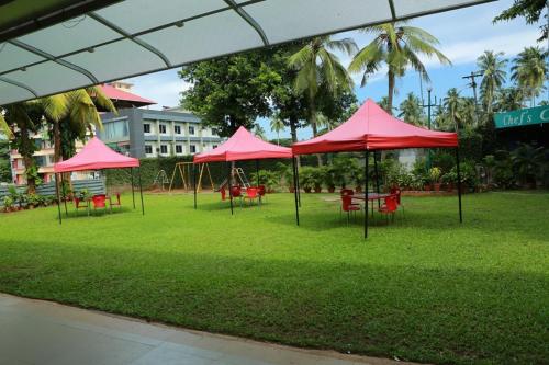 a group of pink umbrellas in a park at Casino Hotels Ltd in Trichūr