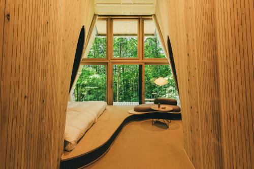 a room with a bed and a large window at SANU 2nd Home 八ヶ岳2nd in Hokuto