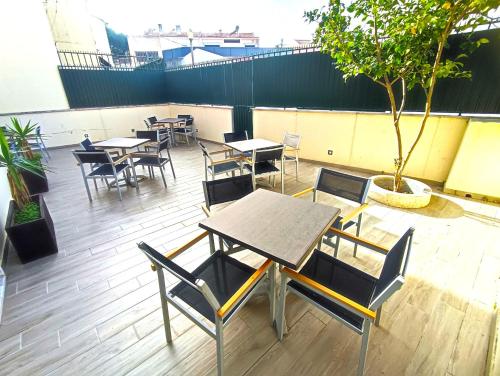 a patio with tables and chairs and a tree at Lisbon Airport GuestHouse GAL Olivais Conforto, Terraço e Localização Premium nos Olivais in Lisbon