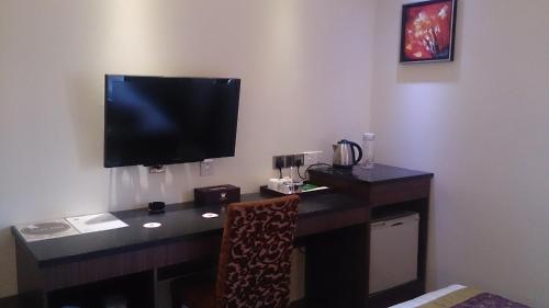 a desk with a television on a wall at Hotel & Apartment Ambassador 3 in Labuan