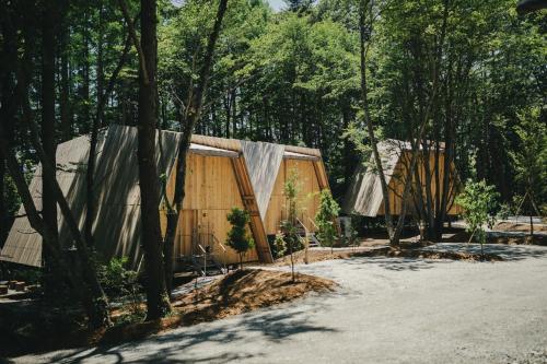 a couple of houses in a forest with trees at SANU 2nd Home 八ヶ岳2nd in Hokuto