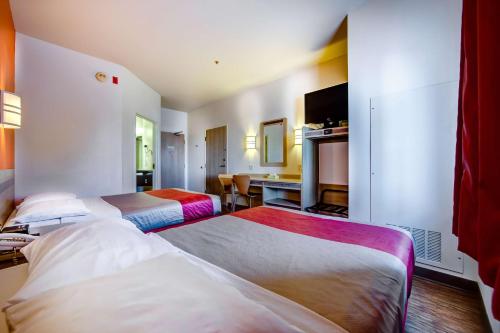 a hotel room with two beds and a desk at Motel 6-Burlington, ON - Toronto West - Oakville in Burlington