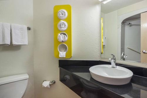 a bathroom with a sink and a toilet and a mirror at Motel 6-Whitby, ON - Toronto East in Whitby