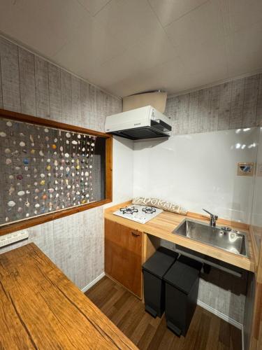 a small kitchen with a sink and a stove at YADOKARI miyakojima in Miyako-jima