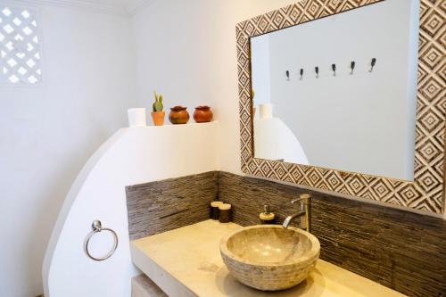 a bathroom with a bowl sink and a mirror at Villa Leelavadee in Uluwatu