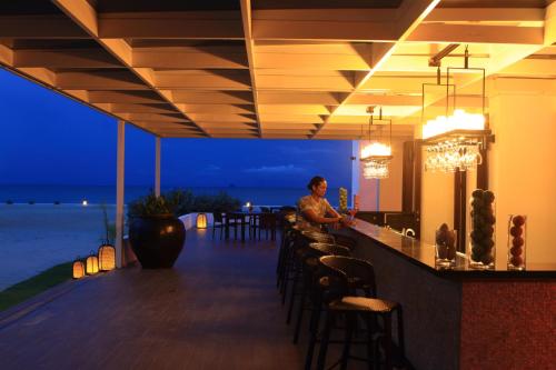 a man standing at a bar at a resort at Kandaya Resort in Daanbantayan