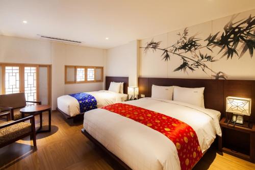 a hotel room with two beds and a desk at Gyeongwonjae By Walkerhill in Incheon
