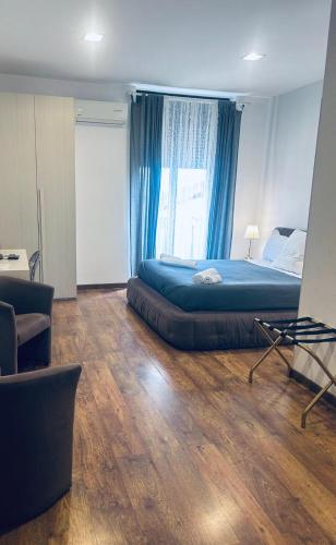 a bedroom with a large bed with blue curtains at Bed & breakfast Frida in Catania