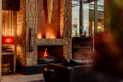 a living room with a stone fireplace with a couch at Pezula Nature Retreat in Knysna