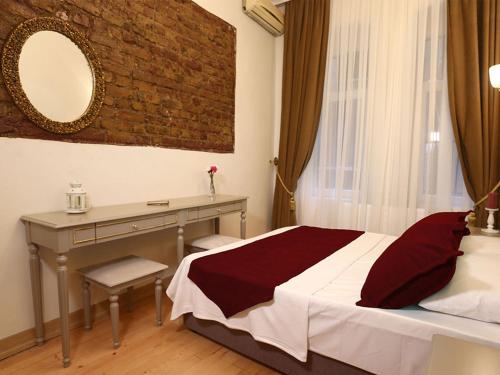 イスタンブールにあるGreen Star Taksim Hotelのベッドルーム(ベッド1台、デスク、鏡付)