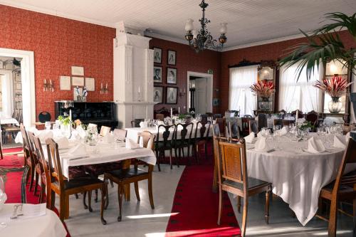 ein Esszimmer mit weißen Tischen und Stühlen in der Unterkunft Tertin Kartano in Mikkeli