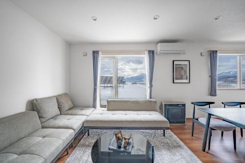 a living room with a couch and a table at Stellavia in Nakafurano