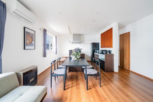 a dining room and living room with a table and chairs at Stellavia in Nakafurano