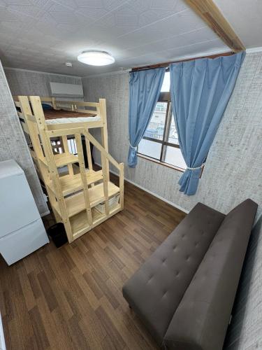 a room with a bunk bed and a couch at YADOKARI miyakojima in Miyako-jima