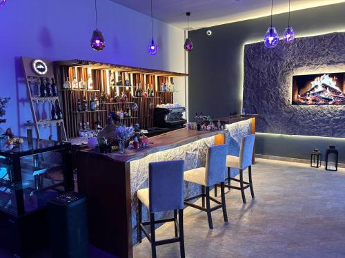 un bar in una stanza con sedie e un camino di Kechi House a Tsaghkadzor