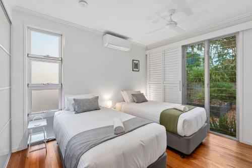 a bedroom with two beds and a window at The Hideaway Currumbin in Gold Coast