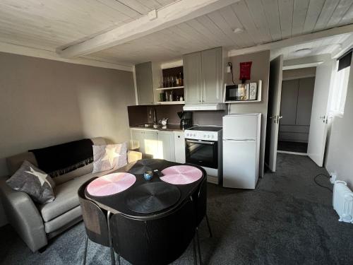 a living room with a couch and a table and a kitchen at Little House in Bäckaskog in Fjälkinge