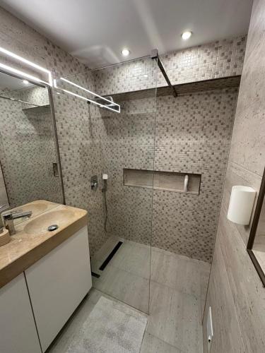 a bathroom with a glass shower with a sink at Zen 2 Bedroom Apartment with Terrace in Zalău
