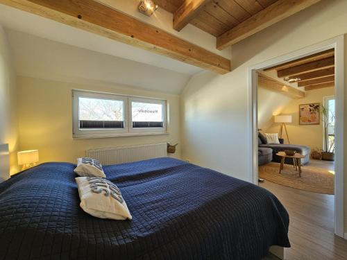 a bedroom with a bed with a blue comforter at Küstenglück 3 Modernes Maisonette-Apartment mit Meerblick & Kickerspaß - 200m zum Strand & Bäcker in Dahme