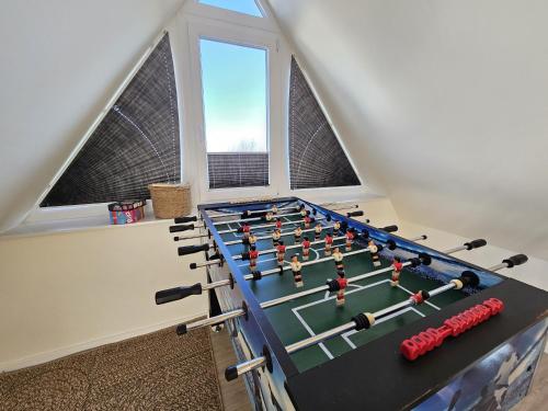 a room with a ping pong table in a attic at Küstenglück 3 Modernes Maisonette-Apartment mit Meerblick & Kickerspaß - 200m zum Strand & Bäcker in Dahme