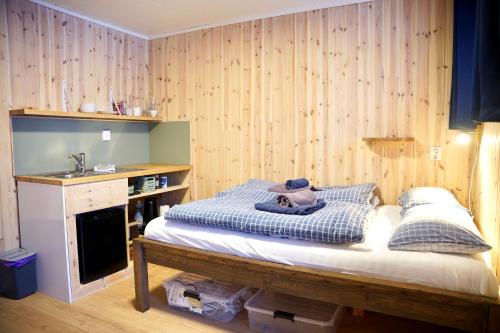 a small bedroom with a bed and a sink at Ingridstua Huskyfarm Innset in Bardu
